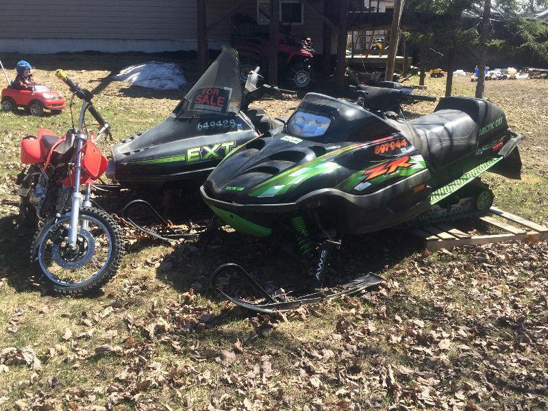 two snowmobiles one dritbike