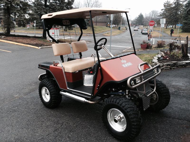 Side by side Ezgo Golf Cart resting on a 500 cc Suzuki ATV